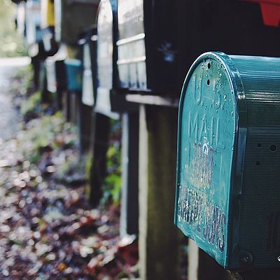 Anreihung einiger am Wegrand stehender Postkästen