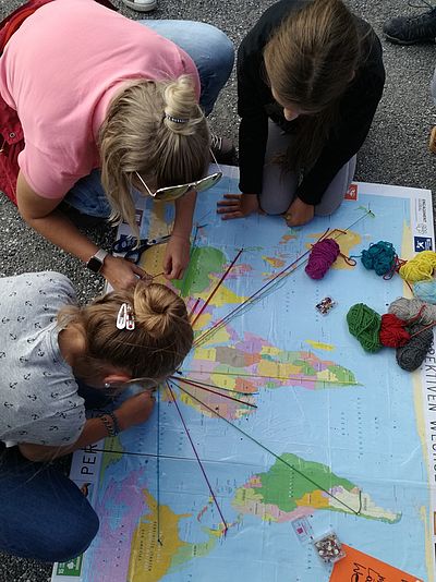 Mädchen beim Spielen mit einer Weltkarte 