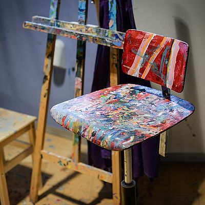 Staffelei und mit Farbe bedeckter Stuhl