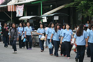 Einheitlich gekleidete Arbeiterinnen auf dem Weg in die Fabrik