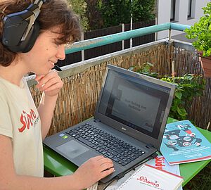 Teilnehmerin eines Webinars zum Thema Klima mit ihrem Laptop