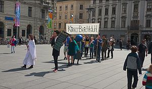 Jugendgruppe Graz bei einem öffentlichen Auftritt mit Banner und Verkleidungen