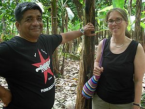 Eine Südwind Mitarbeiterin steht neben einem Mann auf einer Bananenplantage in Ecuador