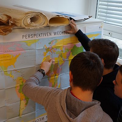 Schüler bei der Betrachtung der Weltkarte im Rahmen des Workshops Menschenrechte und Migration