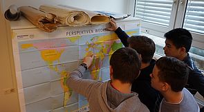 Schüler bei der Betrachtung der Weltkarte im Rahmen des Workshops Menschenrechte und Migration