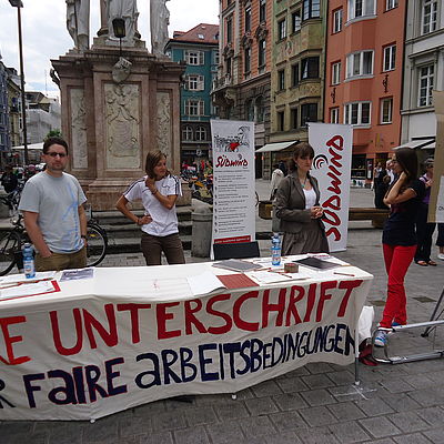 Südwind AktivistInnen sammeln an einem Informationsstand Unterschriften für faire Arbeitsbedingungen 