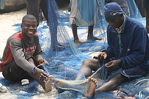 Männer beim Flicken der Netze