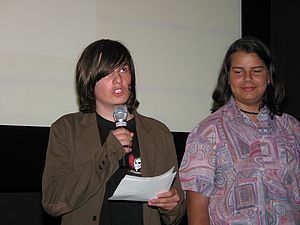 Zwei Schüler auf der Bühne beim Südwind Filmpreis. Einer von beiden spricht ins Mikrofon