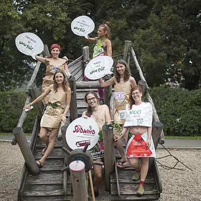 Sechs verkleidete AktivistInnen auf einem Kinderspielplatz
