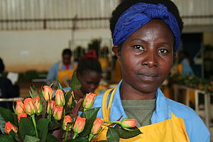 Arbeiterin hält einen Strauß Blumen