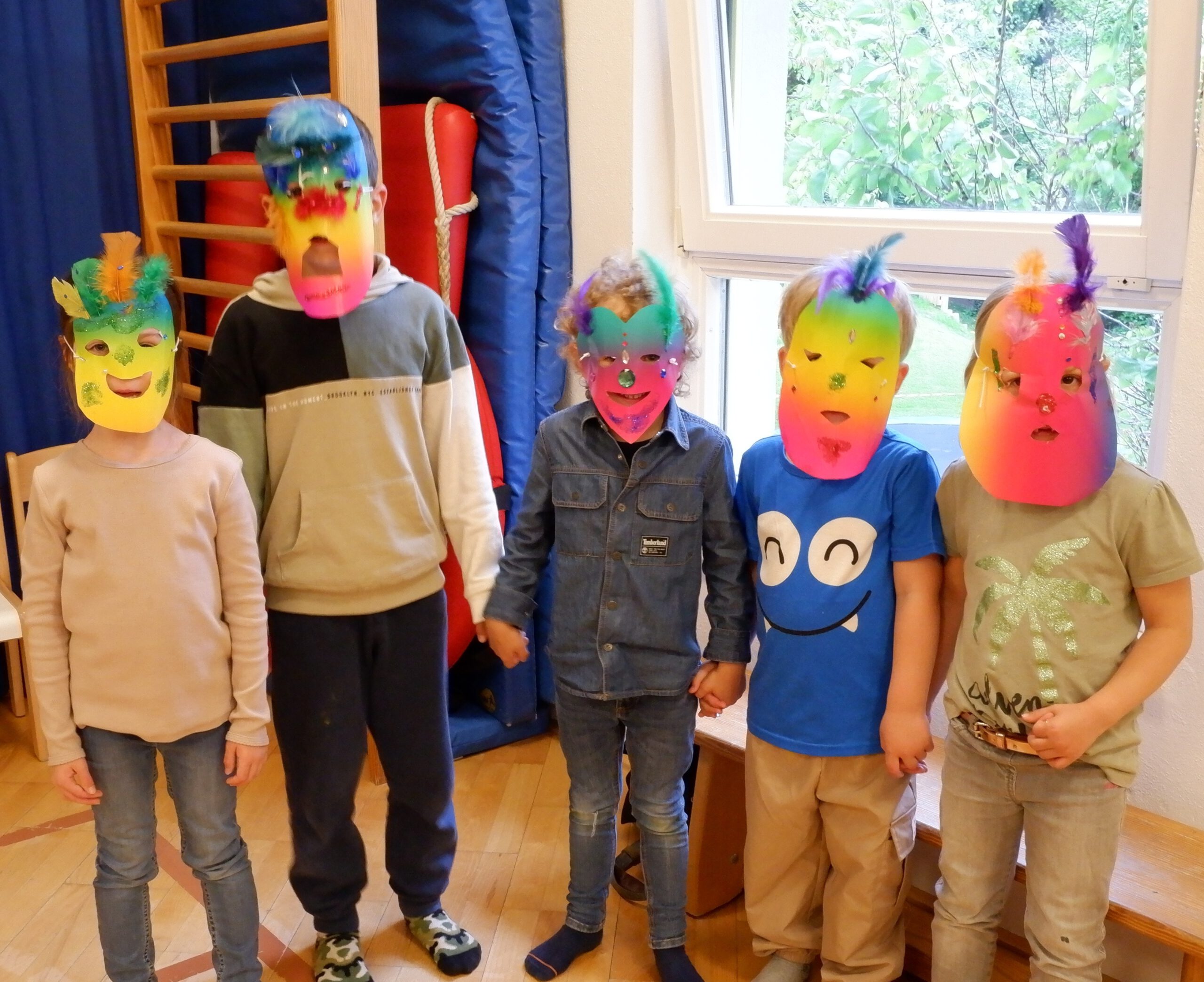 20250515_Creative Storytellers_Klimaheldinnen_(c)Suedwind_verkleinert Gruppenfoto von 5 Kindern, die bunte Masken aufgesetzt haben.