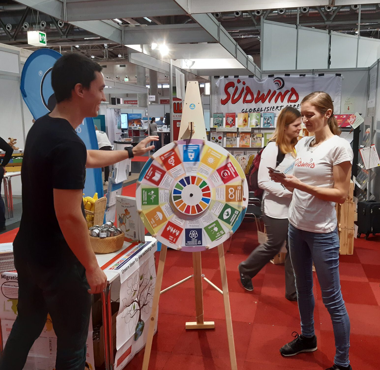 Ein Besucher dreht am SDG-Quizrad am Südwind-Stand zu Globalem Lernen auf der Interpädagogica.