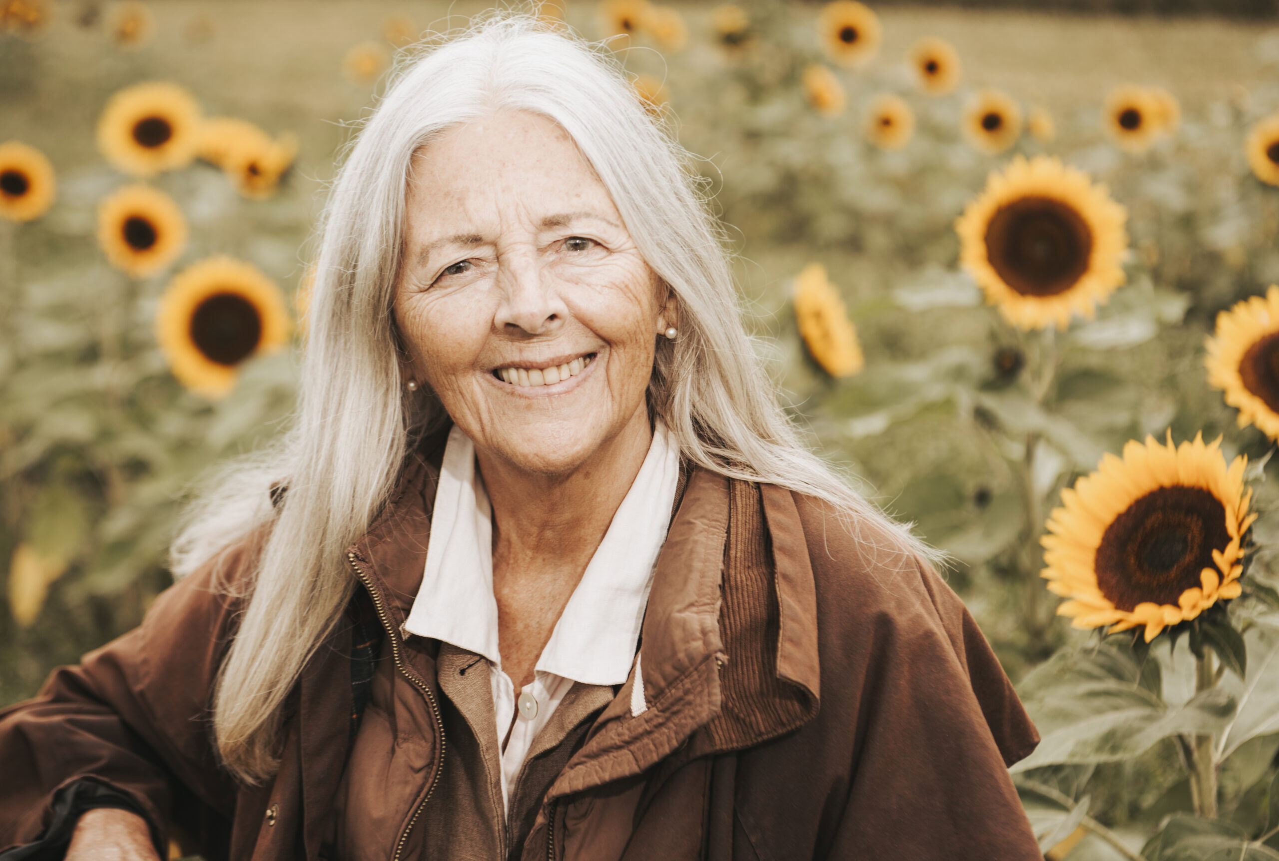 Helena Norber-Hodge Portrait von Helena Norberg-Hodge vor einem Sonnenblumenfeld