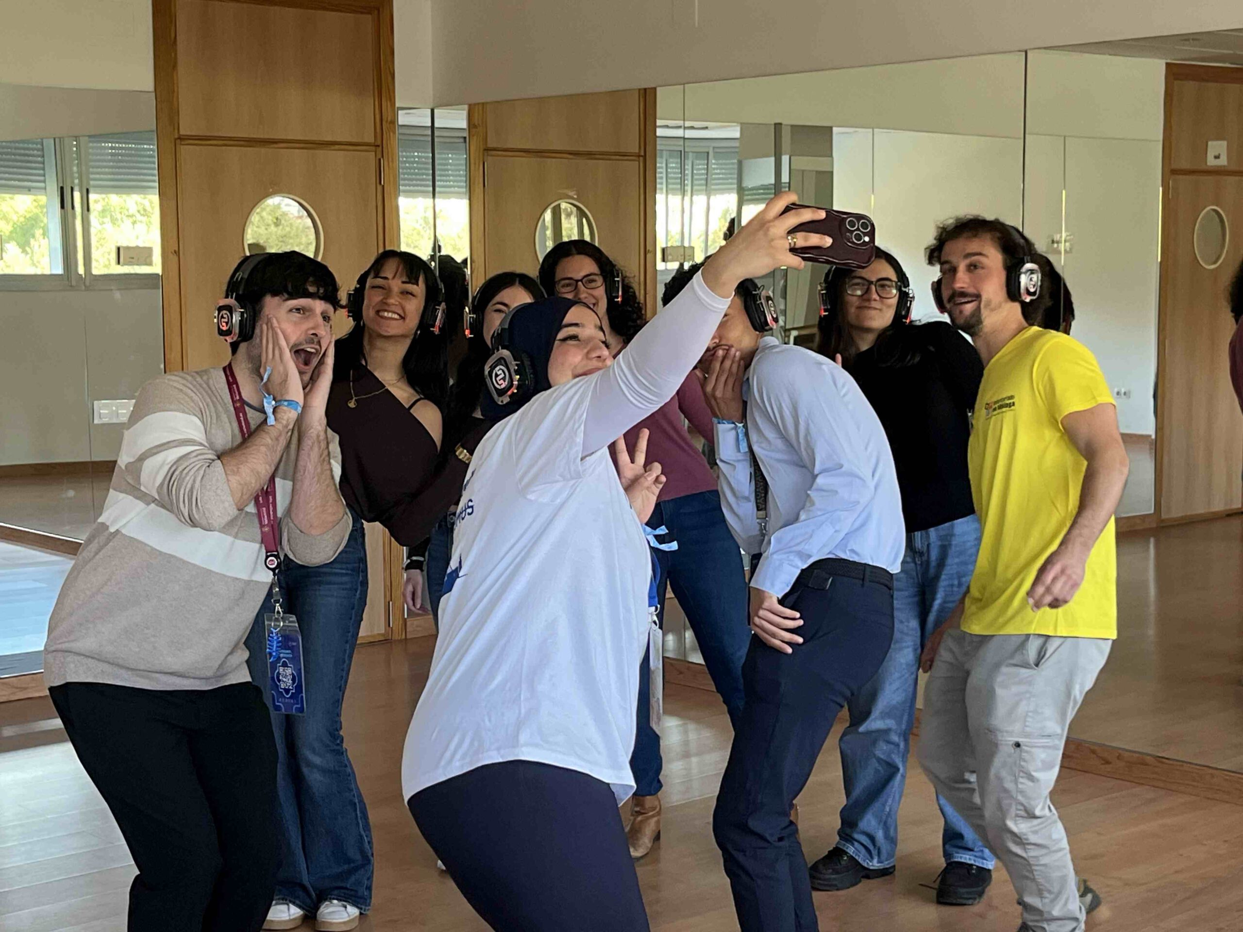 Eine Gruppe von Jugendlichen mit Kopfhörern auf den Ohren posieren für ein Selfie.